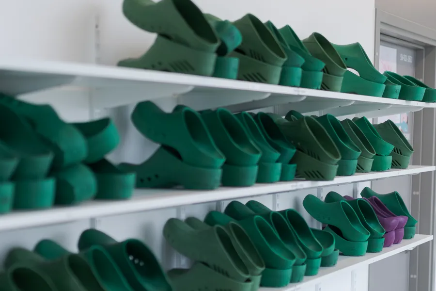 A group of green shoes on a shelf