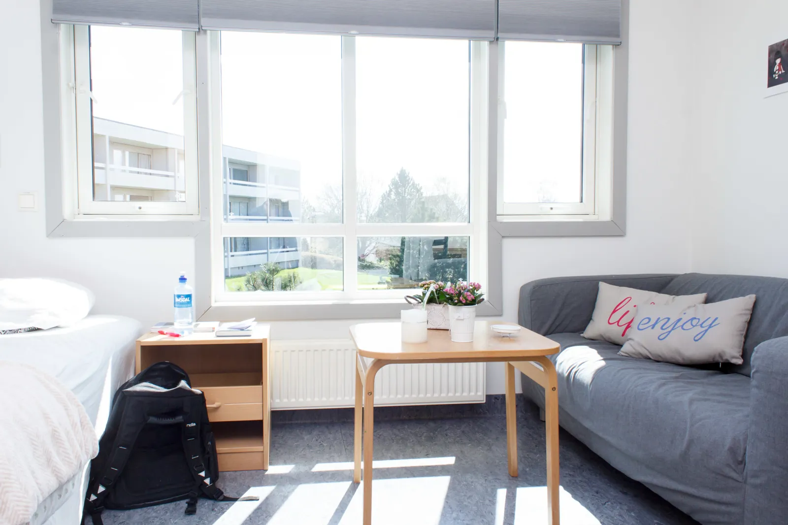 Et rom med en seng og et bord med vindu