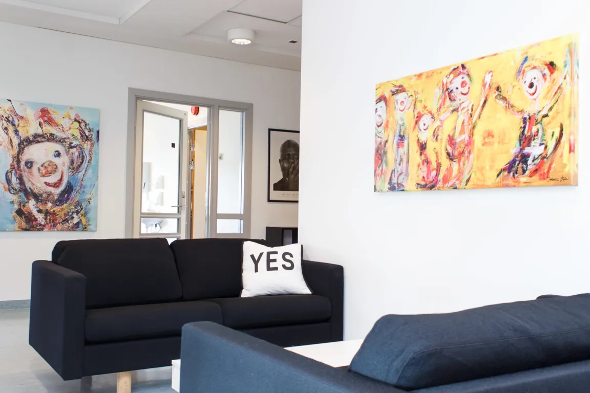 Et rom med sofa og et maleri på veggen