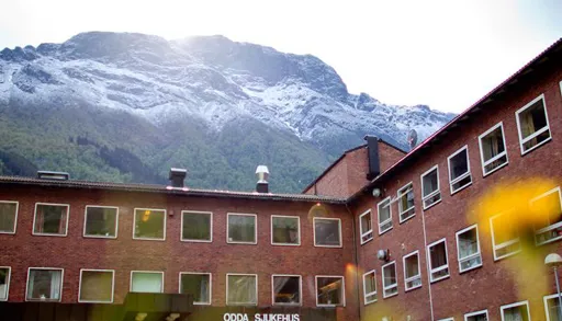 En bygning med et fjell i bakgrunnen